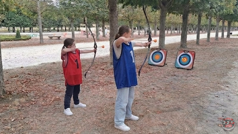 Deux enfants au tir à l'arc, cible posée au sol